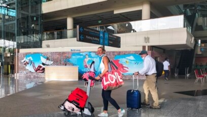 Turis asing membawa barang bawaan mereka setibanya di Bandara Internasional I Gusti Ngurah Rai, saat pemerintah setempat memulai hari pertama uji coba 'bebas karantina', di tengah pandemi COVID-19 di Bali, 7 Maret 2022. (REUTERS/Sultan Anshori)