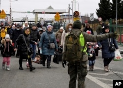 Un guarda fronterizo polaco guía a refugiados ucranianos en el cruce de Korczowa, Polonia, el 5 de marzo de 2022.