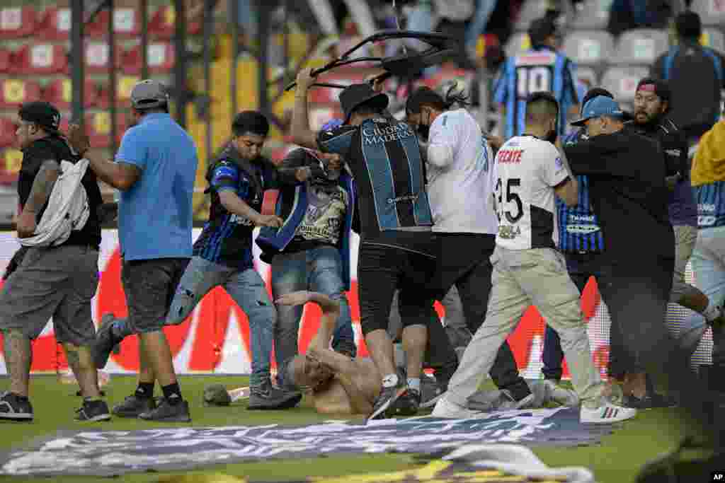 Fans clash during a Mexican soccer league match between the host Queretaro and Atlas from Guadalajara, at the Corregidora stadium, in Queretaro, Mexico, March 5, 2022.