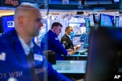 Traders work on the floor, March 7, 2022, in this photo provided by the New York Stock Exchange.