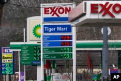 FILE - Gas prices are displayed at gas stations in Englewood, New Jersey, March 7, 2022.