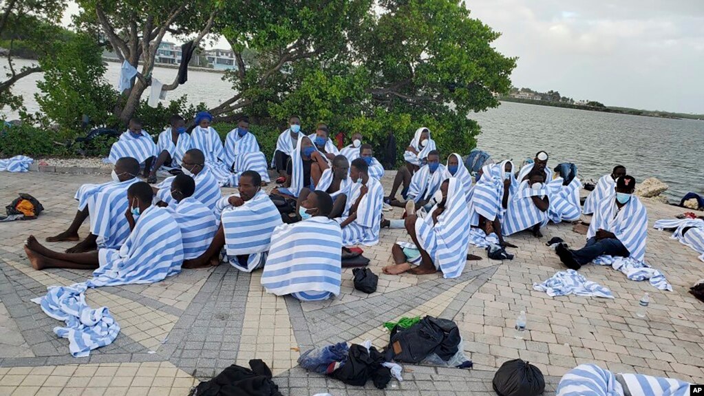 En imagen proporcionada por la Patrulla Fronteriza de Estados Unidos se muestran migrantes haitianos en la costa cubiertos con toallas luego que la embarcación de madera en que viajaran encalló frente a Key Largo, en los cayos de Florida, el 6 de marzo de 2022.