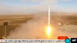 This image taken from video footage aired by Iranian state television on March 8, 2022 shows the launch of a rocket by Iran's Revolutionary Guard carrying a Noor-2 satellite in northeastern Shahroud Desert, Iran. (Iranian state television via AP)