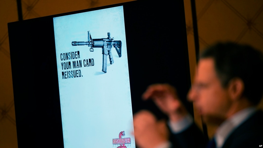 An image of the advertising used for an AR-15-style rifle is displayed while attorney Josh Koskoff speaks during a news conference in Trumbull, Conn., Tuesday, Feb. 15, 2022. (AP Photo/Seth Wenig)