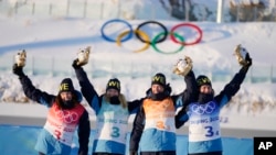 From left, Linn Persson, Mona Brorsson, Hanna Oeberg and Elvira Oeberg of Sweden wave during the venue ceremony after the women's 4x6-kilometer relay at the 2022 Winter Olympics, Feb. 16, 2022, in Zhangjiakou, China.