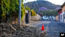 Las rocas llenan una calle después de que la pared de una casa se derrumbara parcialmente tras un terremoto de magnitud 6,2 durante la noche en Antigua, Guatemala, el miércoles 16 de febrero de 2022. 