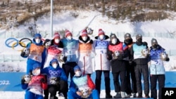 Medalists from Norway, France and the Russian Olympic Committee pose during the flower ceremony after the men's 4x7.5-kilometer relay at the 2022 Winter Olympics, Feb. 15, 2022, in Zhangjiakou, China.