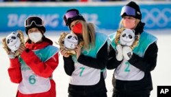 Bronze medalist, from left, Kokomo Murase of Japan, gold medalist Anna Gasser of Austria, and silver medalist Zoi Sadowski Synnott of New Zealand, pose following the women's snowboard big air finals of the 2022 Winter Olympics, Feb. 15, 2022.