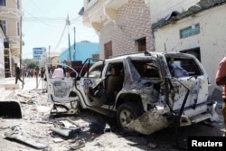 FILE - The vehicle wreckage of Somalia's government spokesperson Mohamed Ibrahim Moalimuu is seen at the scene of an explosion Mogadishu, Somalia, Jan. 16, 2022.