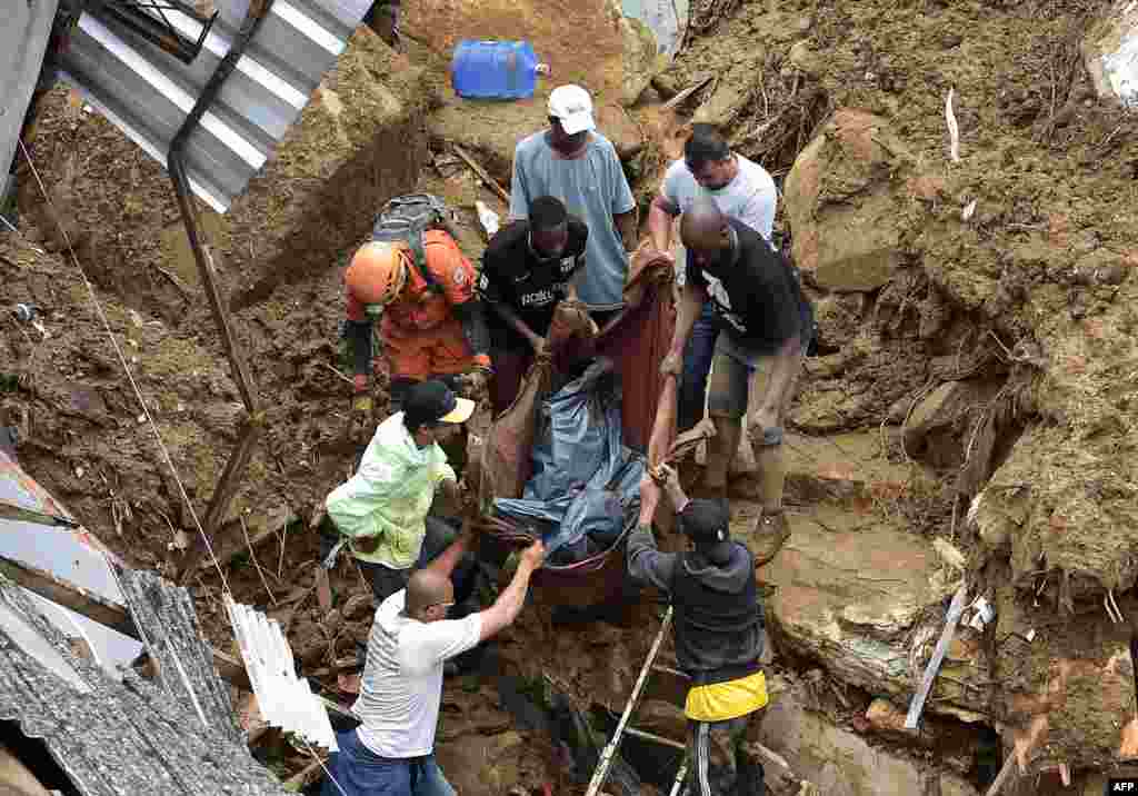 People carry a victim&#39;s body out of the rubble after a mudslide in Petropolis, Brazil.&nbsp;Large scale flooding destroyed hundreds of properties and claimed at least 34 lives in the area.