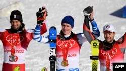 Silver medalist Austria's Johannes Ewald Strolz (L), gold medalist France's Clement Noel (R), and bronze medalist Norway's Sebastian-Foss Solevaag (R) pose on the podium during the men's slalom victory ceremony, Feb. 16, 2022. 