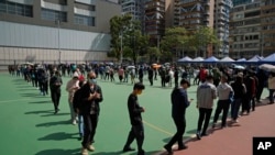 Residents line up to get tested for the coronavirus at a temporary testing center for COVID-19 in Hong Kong, Feb. 11, 2022.