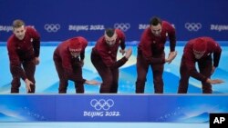 Team Canada celebrate during the victory ceremony after winning the men's 5000-meters relay final during the short track speedskating competition at the 2022 Winter Olympics, Feb. 16, 2022.