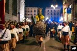 People dressed in traditional costumes perform ''El Ball de l'Àliga'' (Dance of the Eagle) during Saint Eulàlia festivities in Barcelona, Spain, Friday, Feb. 11, 2022.