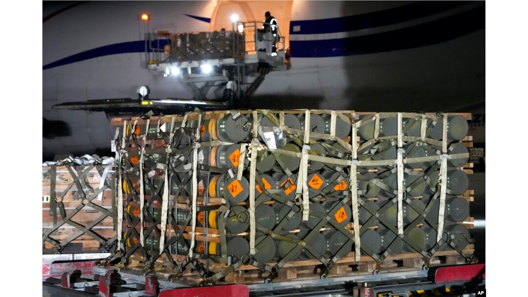 Pekerja membongkar kiriman bantuan militer yang dikirim sebagai bagian dari bantuan keamanan Amerika Serikat ke Ukraina, di Bandara Boryspil, di luar Kyiv, Ukraina, 25 Januari 2022. (Foto: AP)