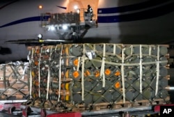 Workers unload a shipment of military aid delivered as part of the United States of America's security assistance to Ukraine, at the Boryspil airport, outside Kyiv, Ukraine, Jan. 25, 2022.