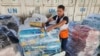 FILE - A United Nations worker prepares aid for distribution to Palestinians at a UNRWA warehouse in Deir Al-Balah, Gaza Strip, on Oct. 23, 2023.
