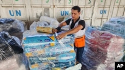 Seorang pekerja PBB menyiapkan bantuan untuk didistribusikan kepada warga Palestina di gudang UNRWA di Deir Al-Balah, Jalur Gaza, pada 23 Oktober 2023.