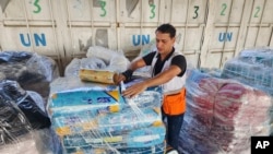 FILE — United Nations and Red Crescent workers prepare the aid for distribution to Palestinians from their warehouse in Deir Al-Balah, Gaza Strip, Oct. 23, 2023.