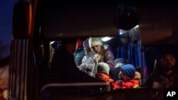 Refugees who fled the war from Ukraine get on the bus at the Medyka border crossing in Poland, on March 12, 2022. 