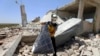 FILE - A civil defense worker inspects a damage house after shelling hit the town of Ibleen, a village in southern Idlib province, Syria, July 3, 2021. 