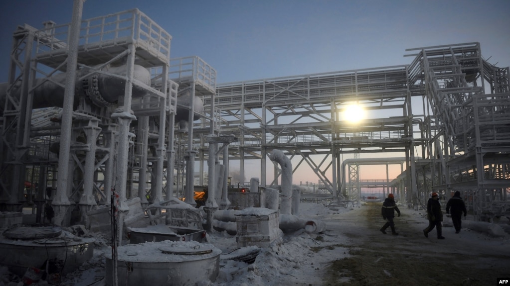 FILE - People walk through the Utrenneye field, the resource base for Russia's Arctic LNG 2 project, located in the Gydan Peninsula on the Kara Sea shore line in the Arctic Circle, some 2,500 kilometers from Moscow, Nov. 30, 2021.