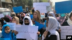Afghan women chant and hold signs of protest during a demonstration in Kabul, Afghanistan, March 26, 2022. Afghanistan's Taliban rulers refused to allow dozens of women to board several flights because they were traveling without a male guardian.