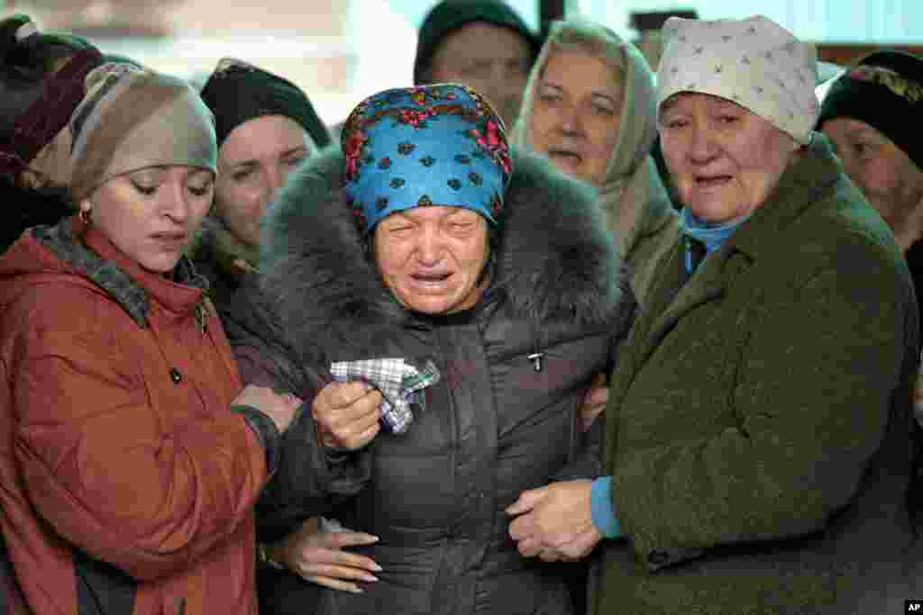 The mother of Russian Army soldier Rustam Zarifulin, who was killed fighting in Ukraine, center, cries surrounded by relatives during a farewell ceremony in his homeland in Kara-Balta, 60 km (37 miles) west of Bishkek, Kyrgyzstan.