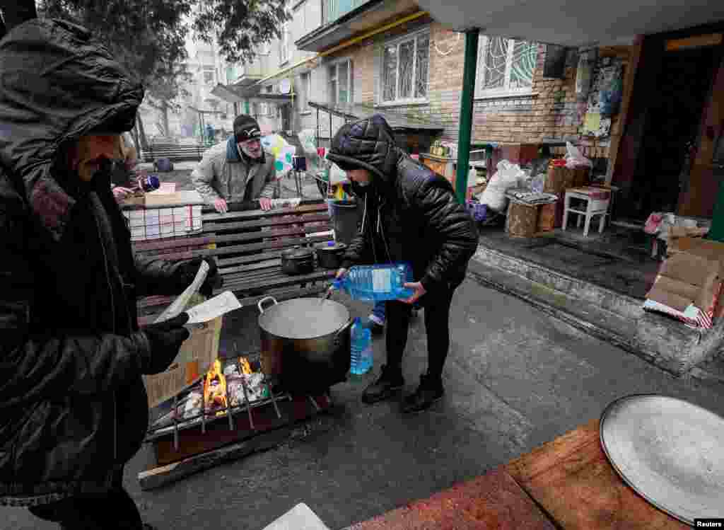 Residentes locales cocinan en el patio de su casa, en medio de la invasión rusa en Ucrania, en Bucha, región de Kiev.&nbsp;