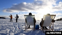 FILE - People enjoy the sunny weather on ice on the waterfront of Helsinki, Finland Feb. 14, 2021.