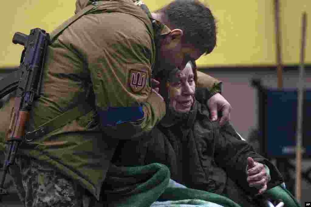 A soldier comforts Larysa Kolesnyk, 82, after being evacuated from Irpin, on the outskirts of Kyiv, Ukraine.