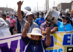 Conductores y residentes protestan en la Autopista Central, donde autobuses y camiones quedaron estacionados para cortar la carrtera, en Huaycan, en las afueras de Lima, Perú, el lunes 4 de abril de 2022.