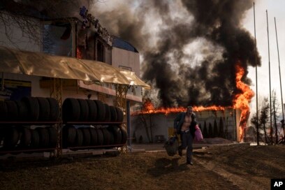 A man recovers items from a burning shop following a Russian attack in Kharkiv, Ukraine, March 25, 2022.