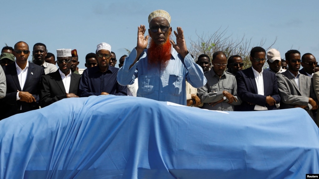 Relatives and Somali government officials pray near the slain body of Amina Mohamed Abdi, a vocal critic of the government, who was killed in a suicide explosion in Beledweyne, at the Adan Abdulle International Airport international in Mogadishu, Somalia, March 24, 2022.