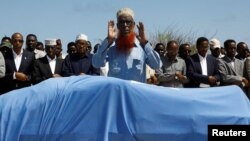 Relatives and Somali government officials pray near the slain body of Amina Mohamed Abdi, a vocal critic of the government, who was killed in a suicide explosion in Beledweyne, at the Adan Abdulle International Airport international in Mogadishu, Somalia, March 24, 2022.
