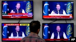 A man watches news channels broadcast a live address to the nation by Pakistan's Prime Minister Imran Khan, in Islamabad, Pakistan, March 31, 2022. 