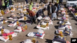 Afghan workers prepare food supplies during a humanitarian aid campaign for poor families, in Kabul, Afghanistan, Feb. 16, 2022.