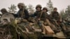 在基辅城外,乌克兰军人坐着装甲车通过被乌军攻破的俄军阵地。(2022年3月31日)