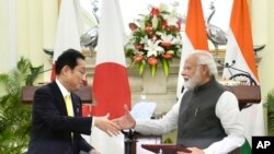 Indian Prime Minister Narendra Modi shakes hand with his Japanese counterpart Fumio Kishida during a signing of agreements in New Delhi, March 19, 2022. Kishida said his country will invest $42 billion in India over the next five years in a deal to boost