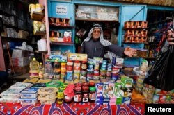 Seorang pedagang Palestina menjual bahan makanan di pasar menjelang bulan suci Ramadhan, di Khan Younis di Jalur Gaza selatan, 30 Maret 2022. (Foto: REUTERS/Ibraheem Abu Mustafa)