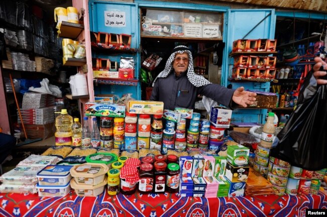 Seorang pedagang Palestina menjual bahan makanan di pasar menjelang bulan suci Ramadhan, di Khan Younis di Jalur Gaza selatan, 30 Maret 2022. (Foto: REUTERS/Ibraheem Abu Mustafa)