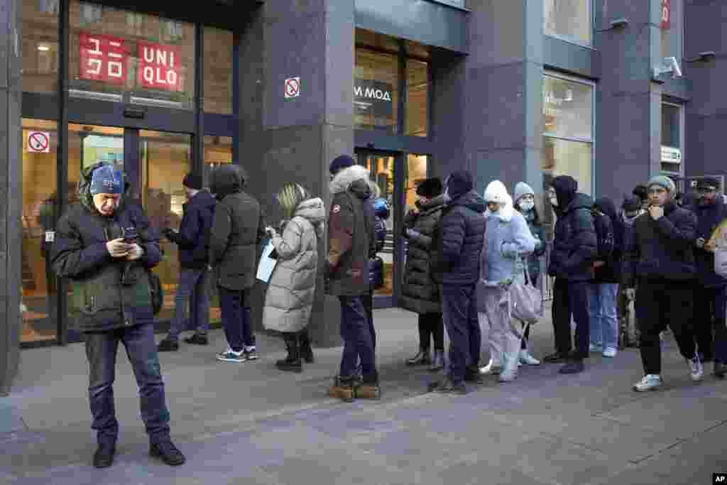 People line up at a Uniqlo store in St. Petersburg, Russia, after an announcement by the Japanese clothing company it is suspending its trade in Russia starting March 21.