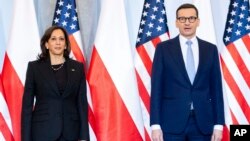 Poland's Prime Minister Mateusz Morawiecki, right, and US Vice President Kamala Harris pose for a photo as she arrives for a meeting, in Warsaw, Poland, Thursday, March 10, 2022. (Saul Loeb/Pool Photo via AP)