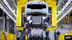 FILE - Workers operate the car assembly line at the new automobile plant of VinFast, Vietnam's first homegrown car manufacturer in Haiphong on June 14, 2019.