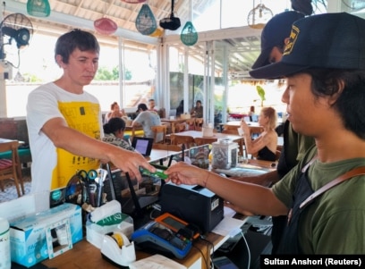 Senator Ruslan, warga Rusia, mencoba menggunakan kartu ATM Rusia miliknya untuk membayar makan siang di Bali. (Foto: REUTERS/Sultan Anshori)