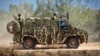 FILE - In this photo provided by the Australian Defense Force, an Australian Army Bushmaster armored vehicle moves off road during a training mission July 7, 2021, in Townsville, Australia. 