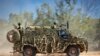 FILE - In this photo provided by the Australian Defense Force, an Australian Army Bushmaster armored vehicle moves off road during a training mission July 7, 2021, in Townsville, Australia. 