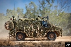 FILE - In this photo provided by the Australian Defense Force, an Australian Army Bushmaster armored vehicle moves off road during a training mission July 7, 2021, in Townsville, Australia.