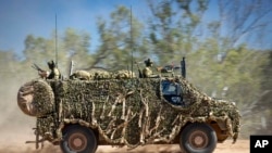 En esta foto proporcionada por la Fuerza de Defensa australiana, un vehículo blindado Bushmaster del ejército australiano sale de la carretera durante una misión de entrenamiento el 7 de julio de 2021 en Townsville, Australia.