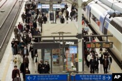 Orang-orang mengenakan masker saat keluar dari kereta api di Stasiun Kereta Api Seoul di Seoul, Korea Selatan, di tengah pandemi COVID-19, Kamis, 17 Maret 2022. (AP/Ahn Young-joon)